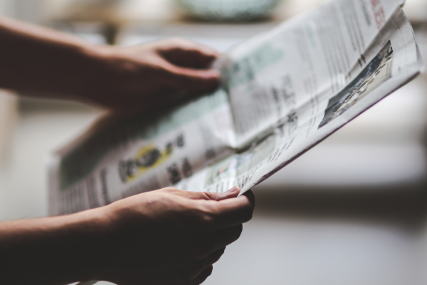 Mann hält eine Zeitung in den Händen